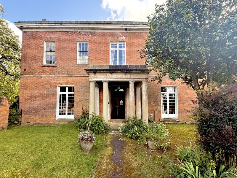 A Colonial Georgian house near Evandale, Tasmania: symmetrical red brick, tall sash windows and a portico on Doric columns