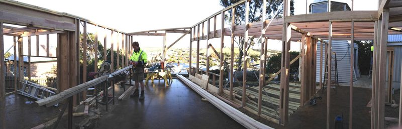 A builder at work inside the new timber frame of an extension