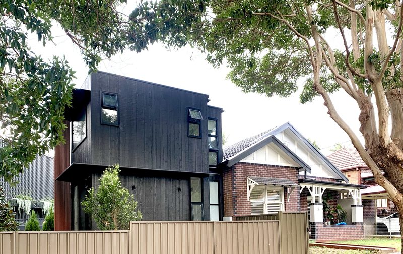 The addition matches the ridge height of the original bungalow, with a clear break between the two buildings. The stair sits in that break, linking them together.