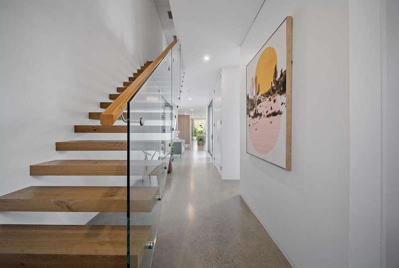 Open timber treads float from the wall, allowing views through the stair
