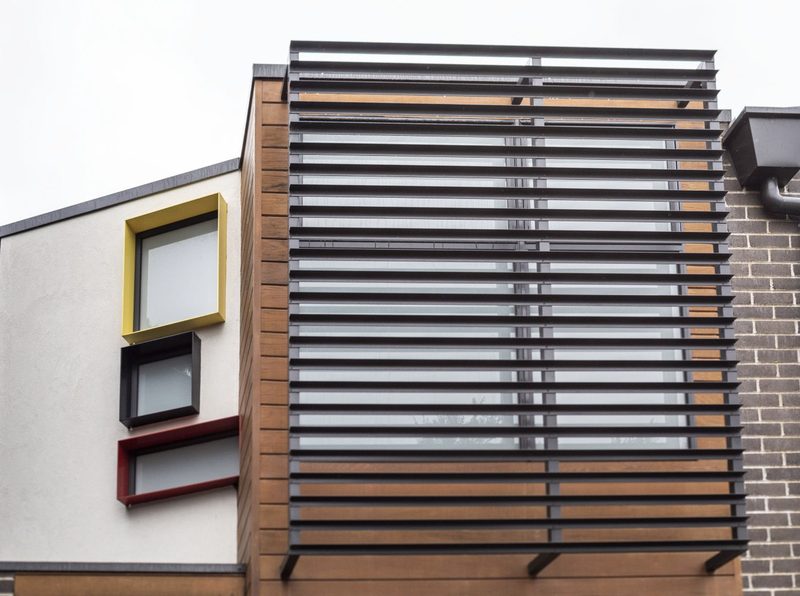 Towards the rear, screening deals with sun and privacy while still letting in natural light. Three windows in primary colours, of different sizes and deliberately out of line, bring light into the master bedroom. Like the yellow door, they’re a bit of fun, and a counterpoint to the more muted finishes through the rest of the house.
