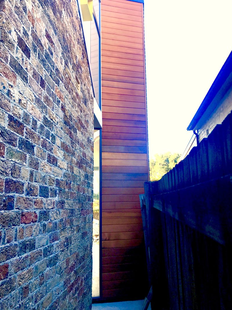 The tall wall shows where the building steps out to meet the boundary at the new side entry. Moving the entry to the side keeps the public and private spaces of the house separate.