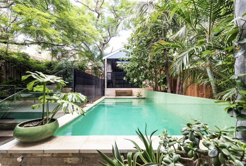 The swimming pool is slightly elevated to work with the contours of the site, and to minimise potential excavation in rock. The garage and carport can be seen at the rear, also raised to minimise the effect of the slope.