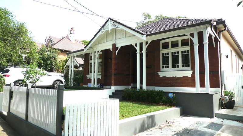 The view from the street was re-imagined with lawn where there was concrete, timber detailing replacing steel columns, and a paling fence to replace the brown gloss, tiled original wall.